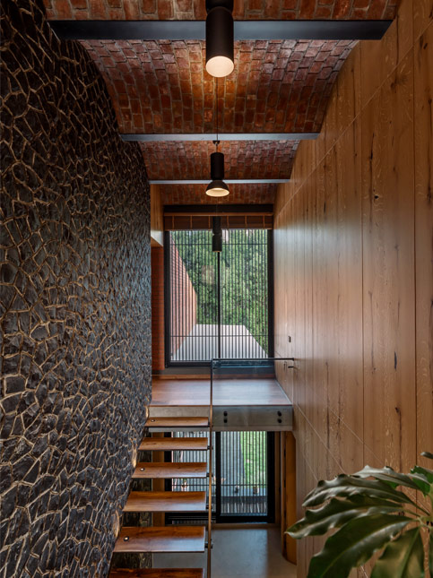 Textural stone wall breaking the monotony of brick and wood in a rustic modern home – Beautiful Homes