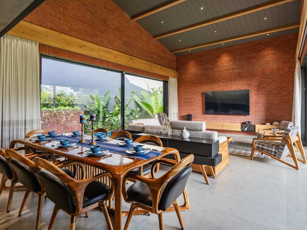 Spacious double-height living and dining area with striking sloping roof design – Beautiful Homes
