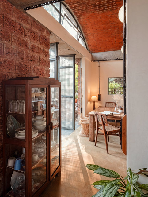 The dining area opens out through large mesh-and-glass doors, allowing cross-breezes to flow in and creating an easy connection between indoor meals and the garden beyond – Beautiful Homes