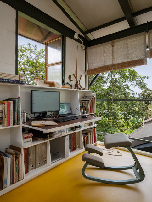 The upper level of the studio functions as an office space, with workstations, and large windows that open to views of the surrounding trees and backwaters – Beautiful Homes