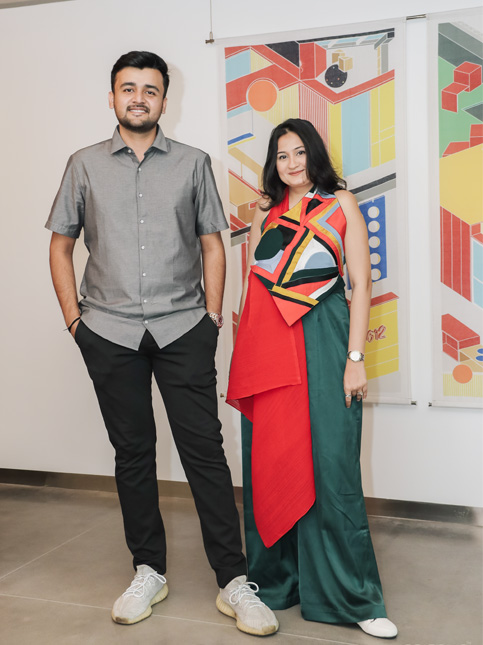 Designers posing in front of colourful geometric artwork at a modern exhibition – Beautiful Homes