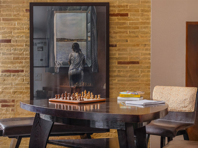Wooden table with chessboard and books against a brick wall – Beautiful Homes