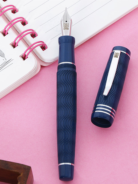 A deep blue fountain pen next to an open spiral notebook– Beautiful Homes