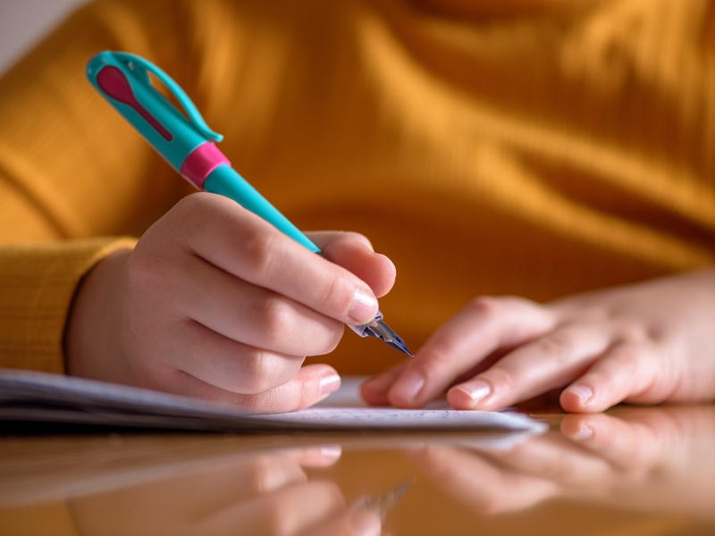 A person writes with a bright teal and pink fountain pen on paper – Beautiful Homes