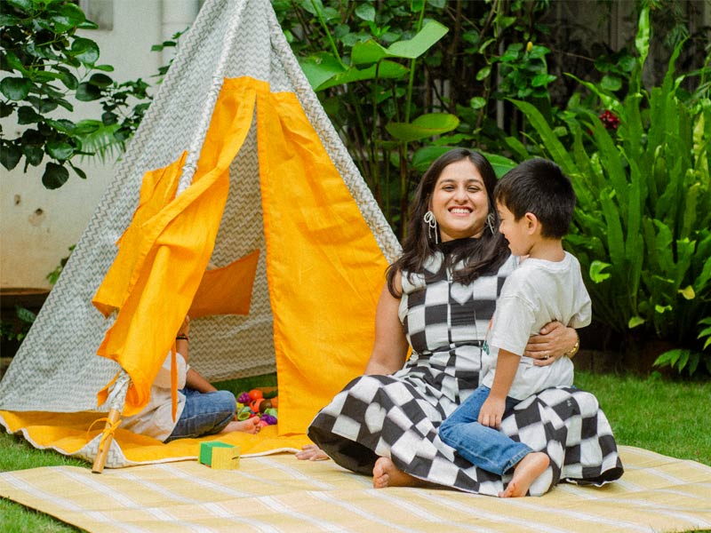 Rohita with her child, picnicking in their garden - Beautiful Homes