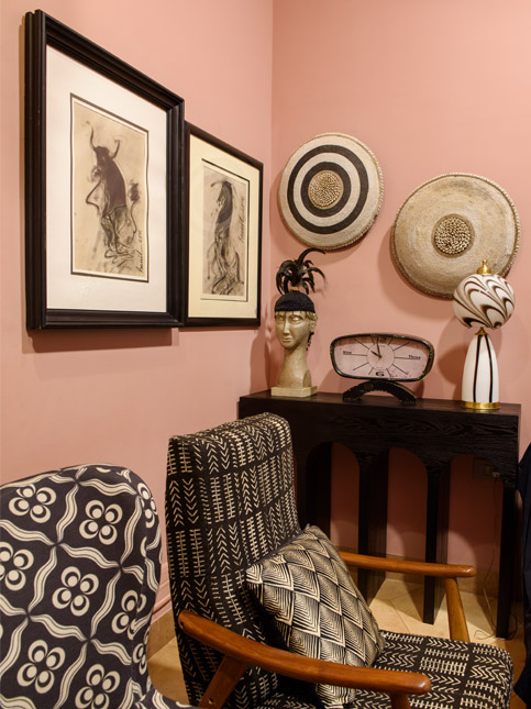 Artistic corner with patterned chairs, framed art, and wall décor on peach-toned walls – Beautiful Homes