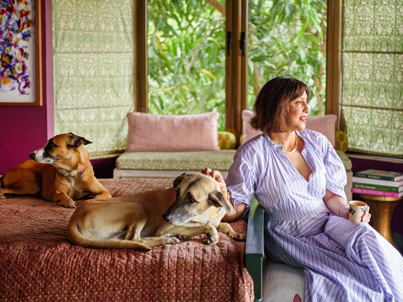 Serene bedroom with lush outdoor view, cozy bedding, and dogs lounging beside the owner – Beautiful Homes