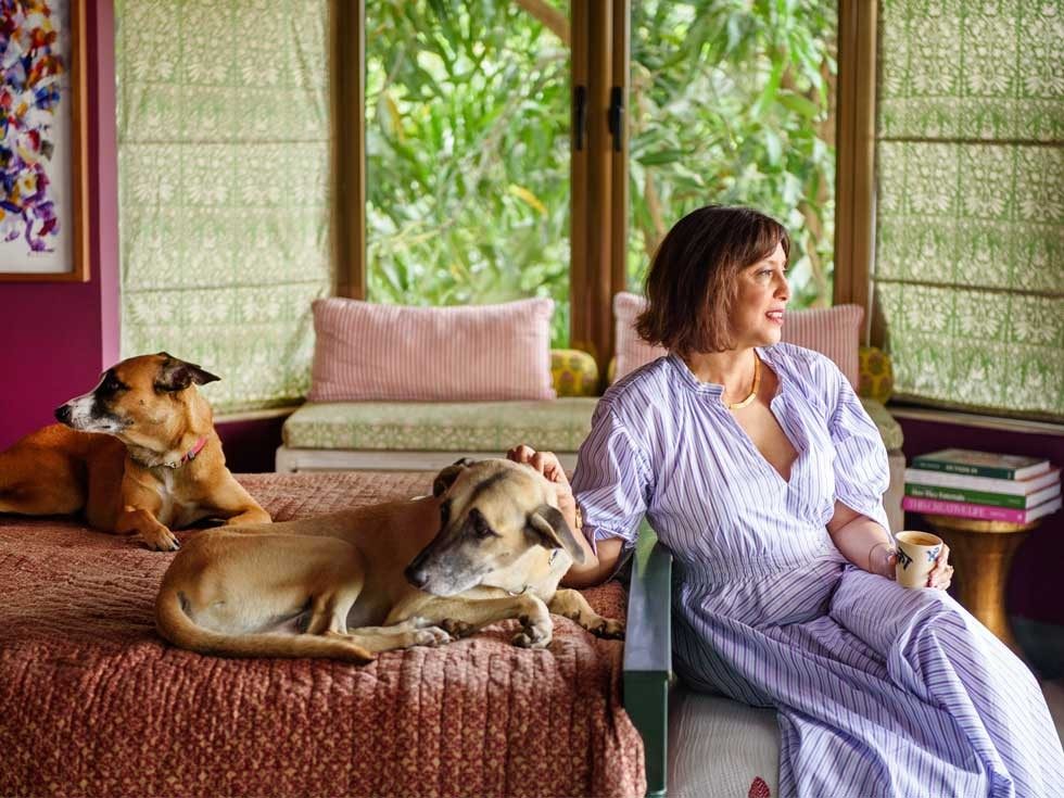 Serene bedroom with lush outdoor view, cozy bedding, and dogs lounging beside the owner – Beautiful Homes