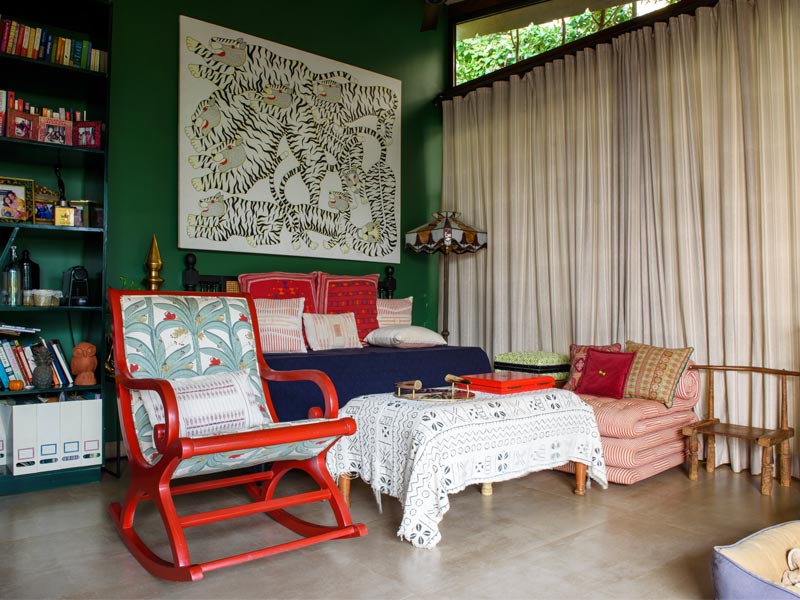 Vibrant living room with patterned furniture, bookshelf, and striking wall art of tigers – Beautiful Homes