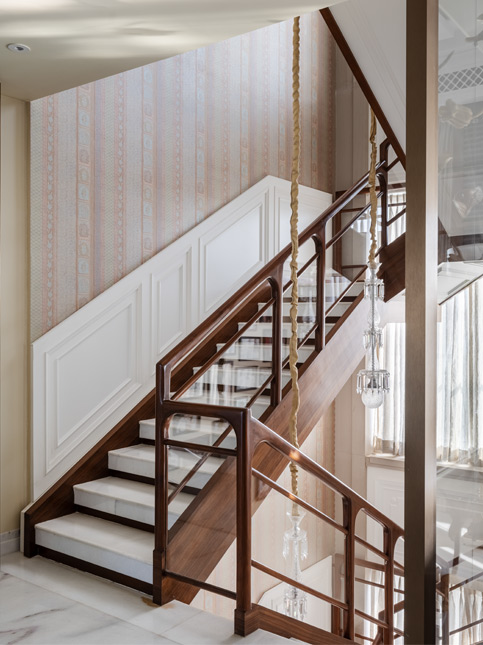 The staircase has a marble finish, wooden railing and wall paper by Sabyasachi for Nilaya to tie the whole house together - Beautiful Homes
