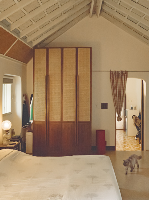 Bedroom with cane wardrobes and bedside lamp – Beautiful Homes