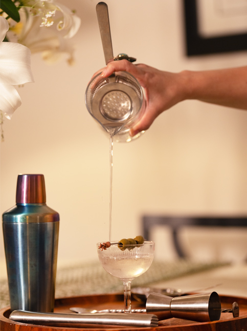 Handcrafted martini poured in a chilled glass garnished with olives - Beautiful Homes