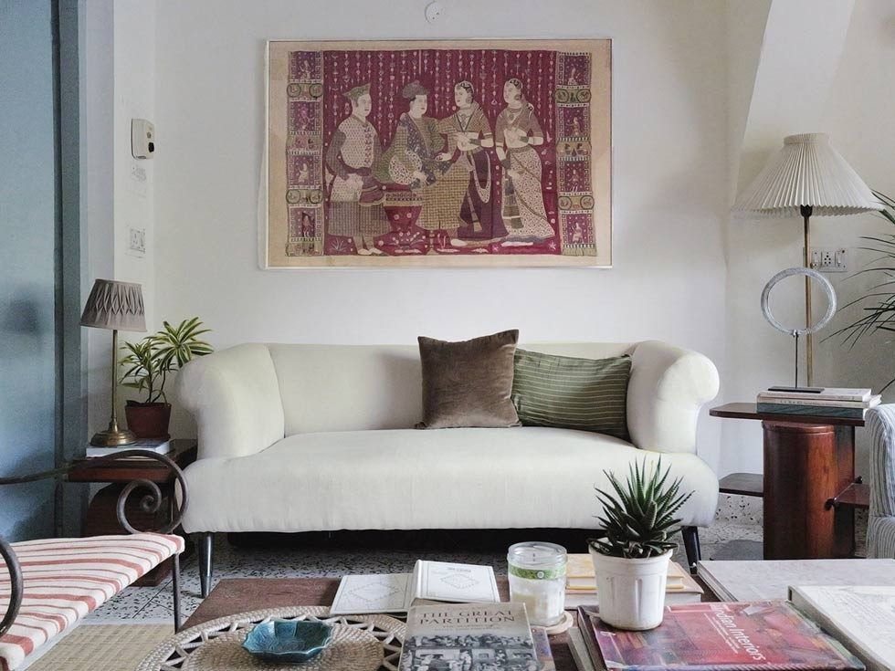 Living room with curved sofa and wall art – Beautiful Homes