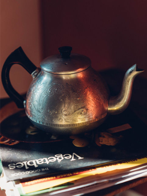 A carved aluminium teapot sits atop a pile of books – Beautiful Homes