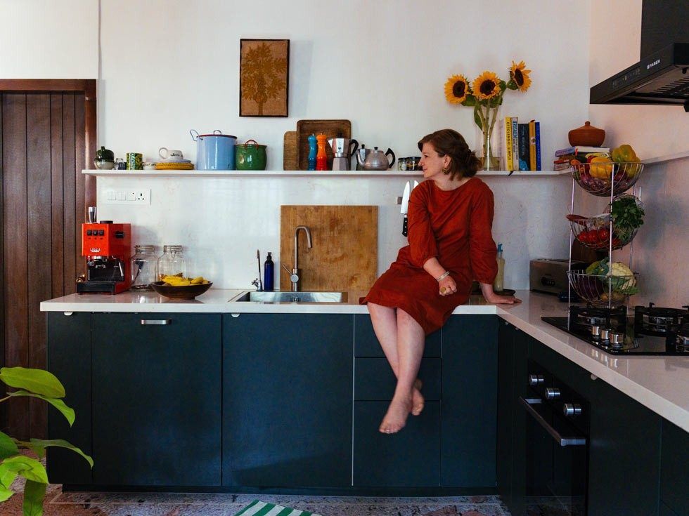 Woman in red dress sitting on a counter looking away – Beautiful Homes