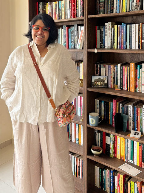Deepika Ramesh beside her bookshelf at home – Beautiful Homes