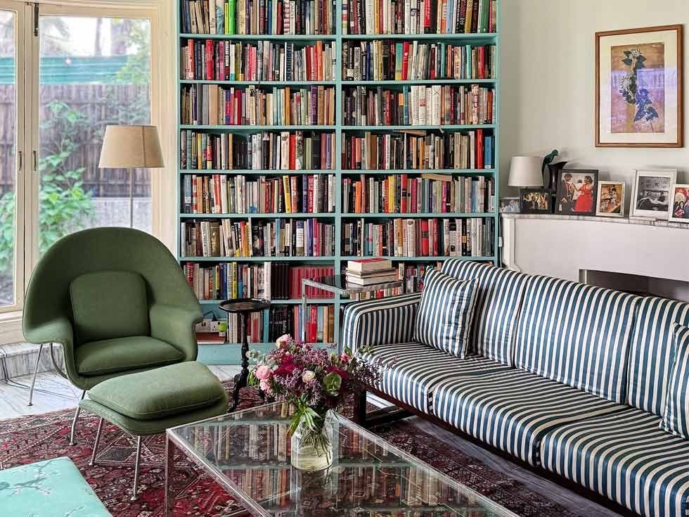 Colorful home library with bookshelf, striped sofa and glass coffee table – Beautiful Homes
