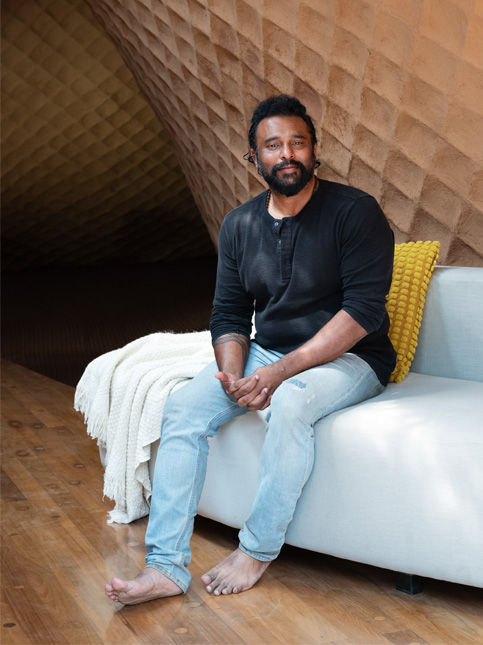Man seated in textured architectural space – Beautiful Homes