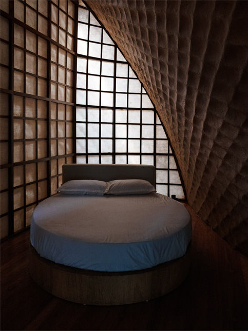 Round bed in textured earth-toned bedroom – Beautiful Homes