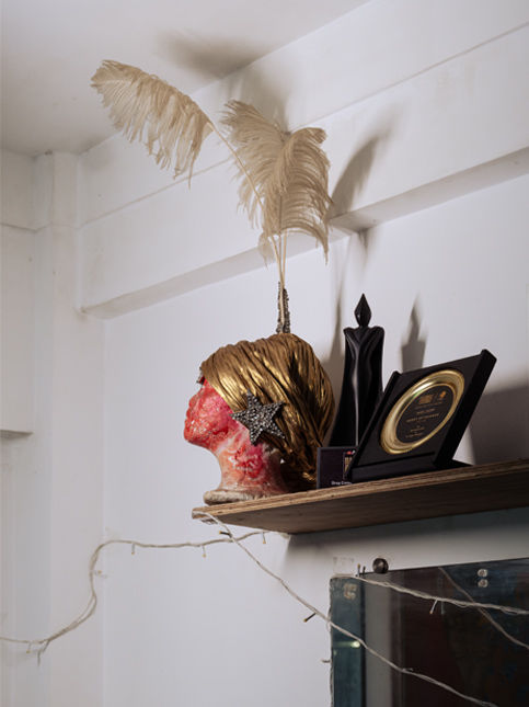 Artistic bust with feathers and awards on wooden shelf – Beautiful Homes