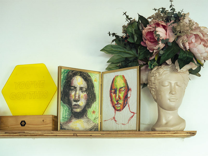 Artistic sketches and sculptural planter on wooden shelf – Beautiful Homes