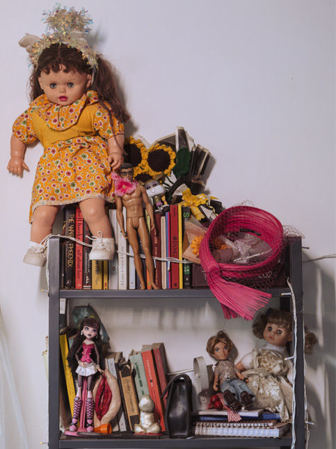 Collection of vintage dolls and books on black shelf – Beautiful Homes