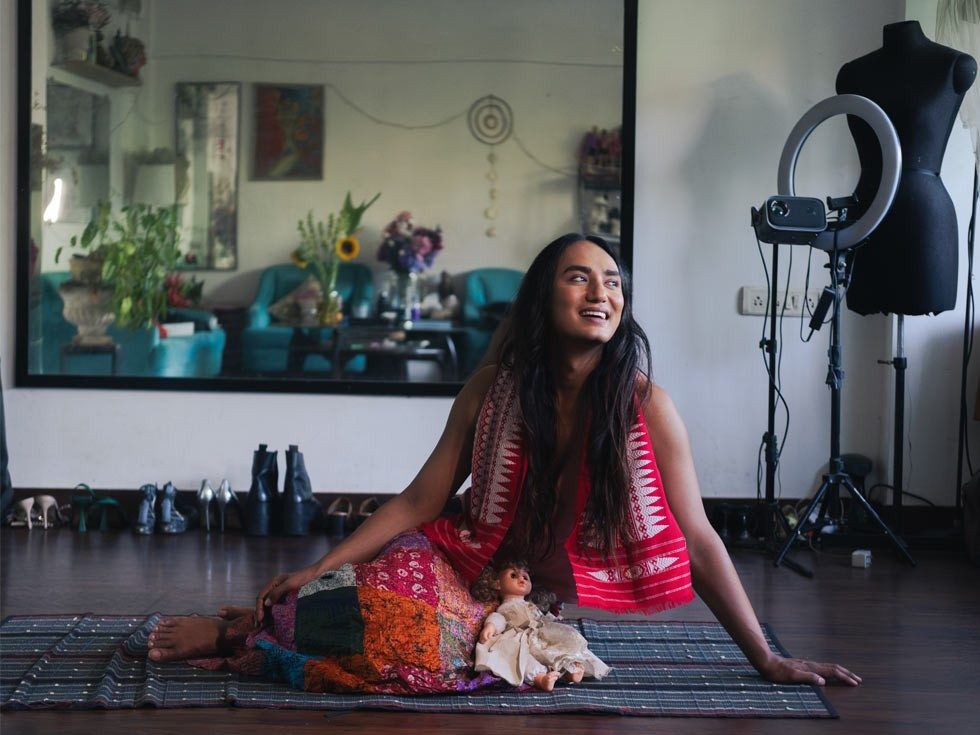 Person in traditional red attire with doll in creative studio – Beautiful Homes