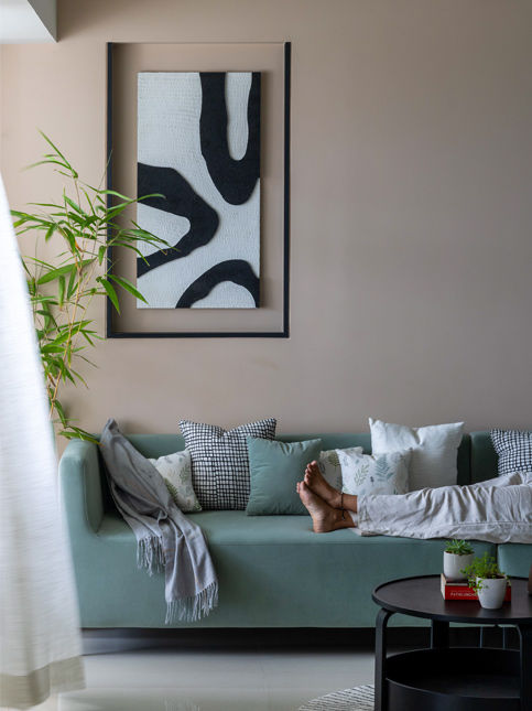 One Habitat Studio modern living room with mint green sofa and abstract wall art – Beautiful Homes