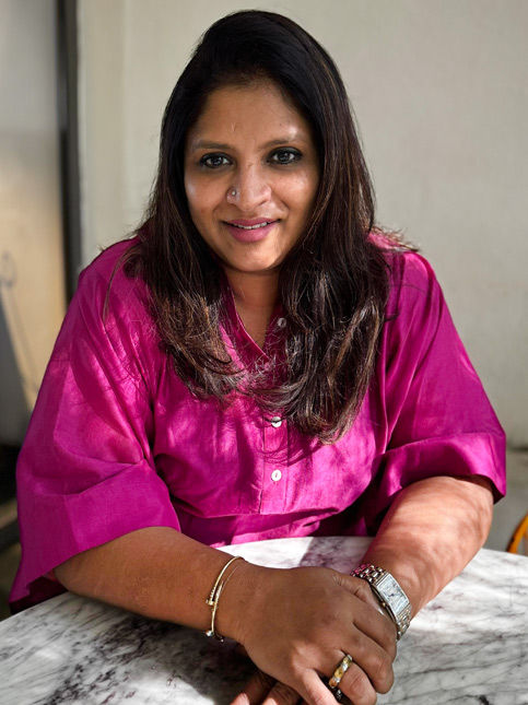 Woman in pink at marble table – Beautiful Homes
