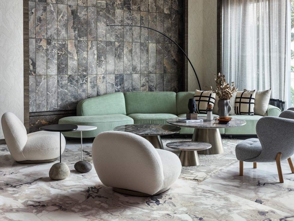 Modern living room with curved green sofa and marble flooring – Beautiful Homes