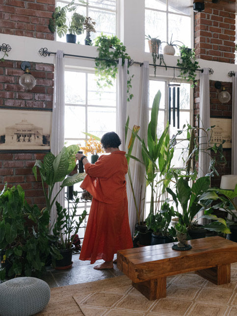 Airy bohemian living room with brick accent walls and lush indoor plants – Beautiful Homes