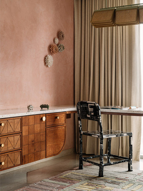 Memory-led lounge with wall objects rugs and chairs in Byculla home - Beautiful Homes