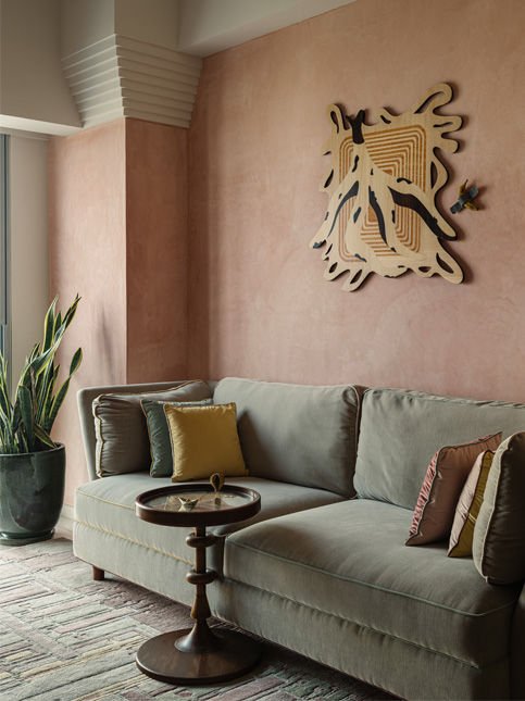 Pink-walled lounge with white ceiling and warm colour palette - Beautiful Homes