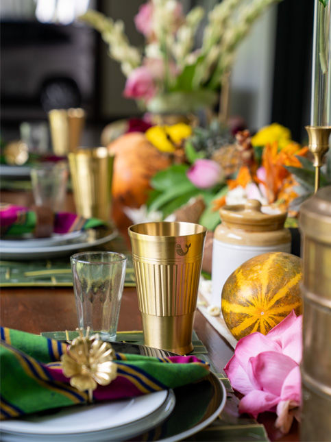 Brass tumblers and napkin rings from Nicobar add a festive touch to the Onam table - Beautiful Homes