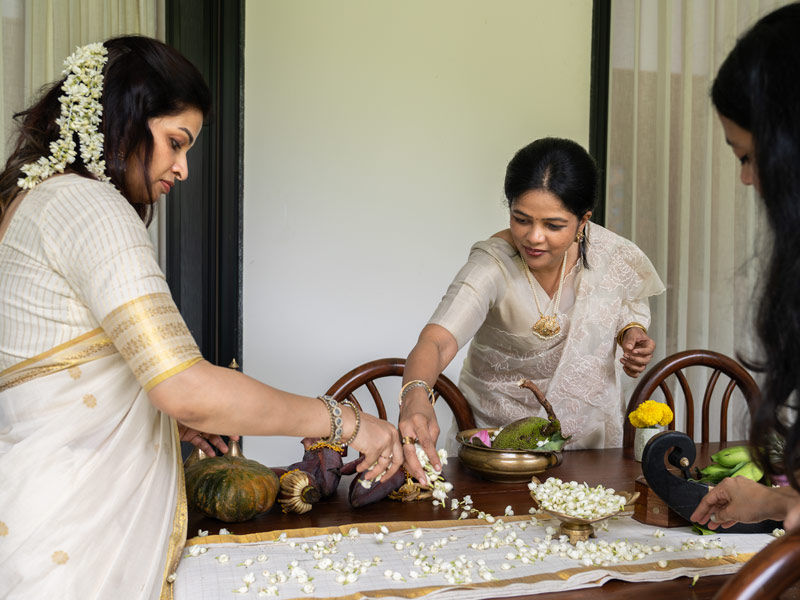 Fymin, Nimitha and Varsha laying fragrant jasmine blossoms on the Onam table - Beautiful Homes