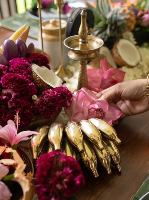 Onam tablescape featuring coconuts, lotus, jasmine, hand-plucked hibiscus and gleaming brass accents - Beautiful Homes
