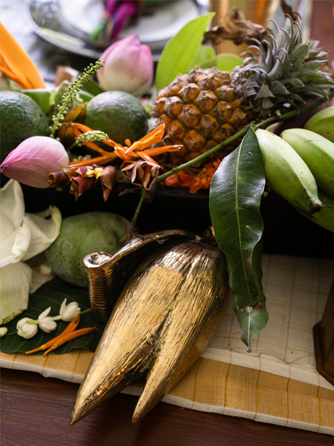 Onam tablescape layered with seasonal produce, familiar blooms and a brass banana blossom from The Vyala Store in Chennai - Beautiful Homes
