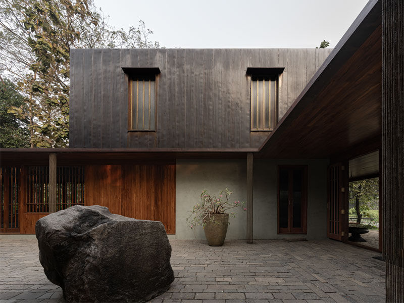 Copper House II courtyard with basalt boulder and copper roof - Beautiful Homes
