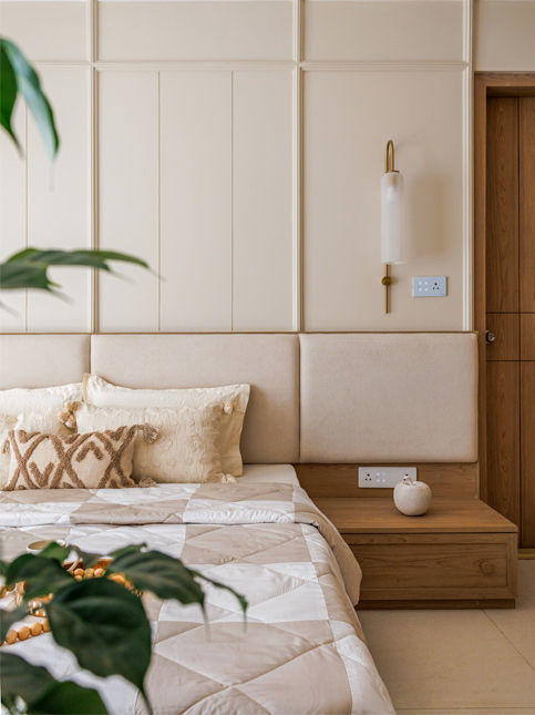 Master bedroom detail with fabric wall panelling and oak nightstands - Beautiful Homes