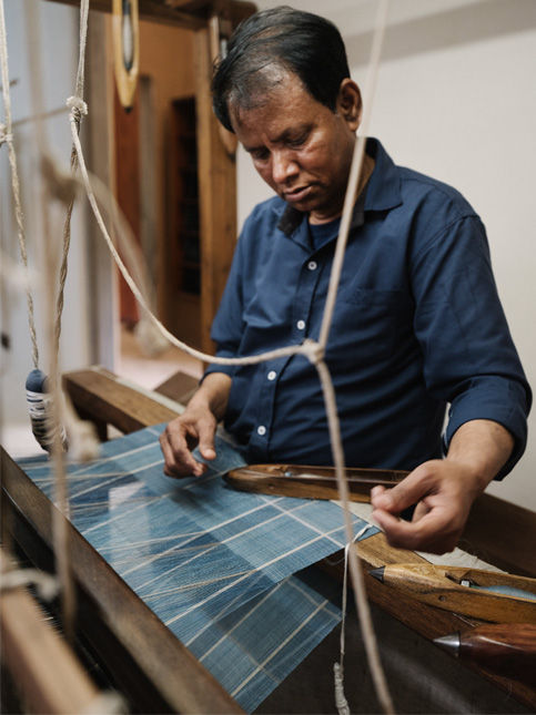 Weaver interlacing weft on traditional loom for patterned textile - Beautiful Homes