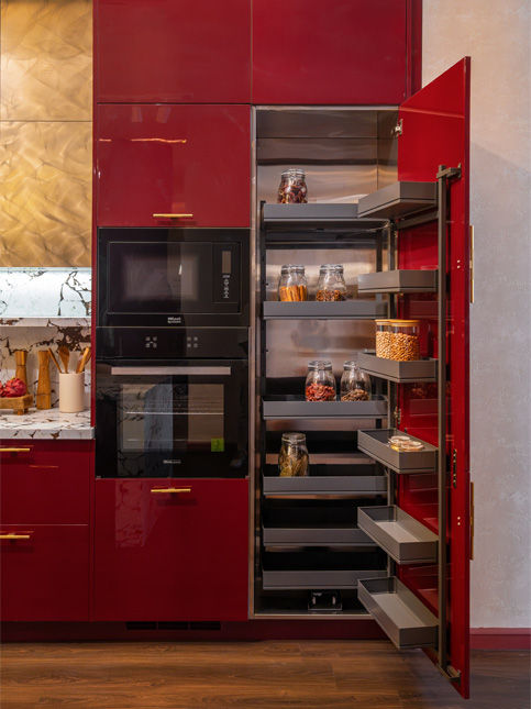 Red and gold modular kitchen with marble island and statement chandelier - Beautiful Homes