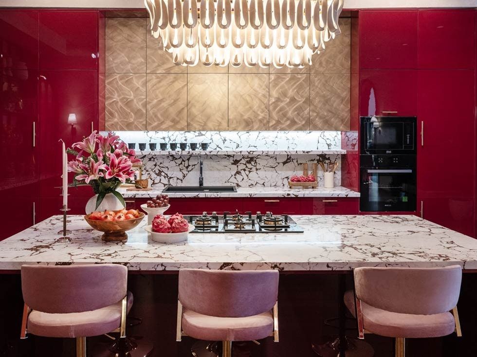 Red and gold modular kitchen with dish rack, marble backsplash and black sink - Beautiful Homes