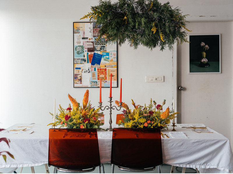Communal table dressed with flowers, candles and place settings for Apartment – Beautiful Homes