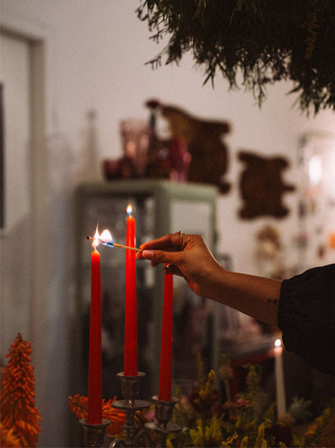 Jayati Jain lighting red taper candles around the dining table before service – Beautiful Homes