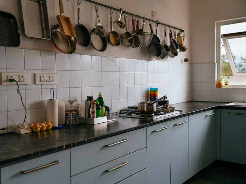 Open Bengaluru kitchen with cookware displayed above the counter for easy access – Beautiful Homes