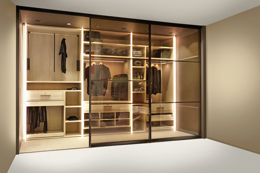A walk-in wardrobe with clothes and other items inside  - Beautiful Homes