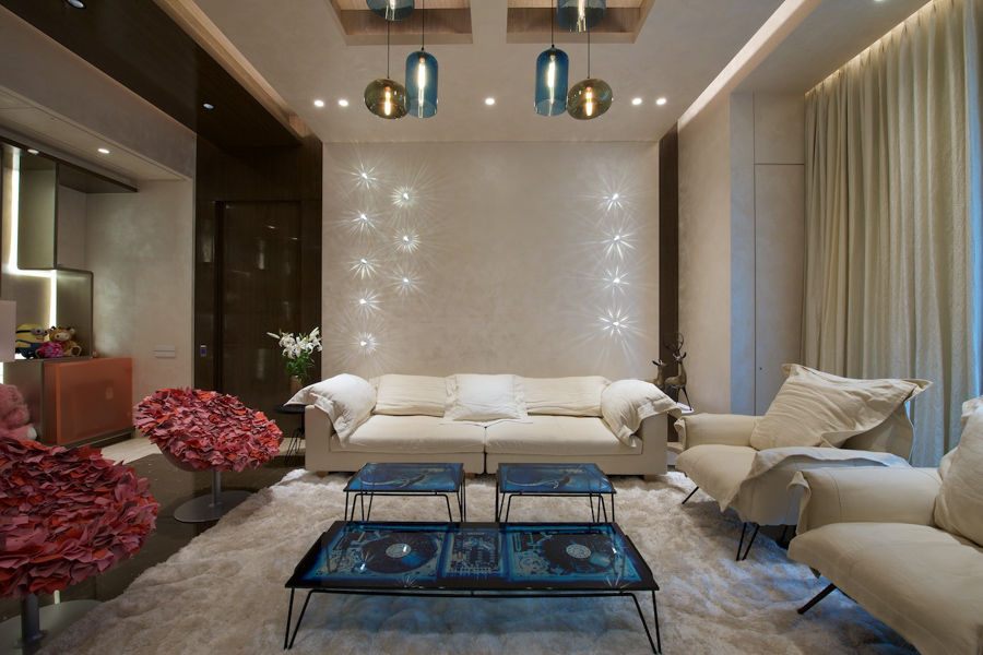 Luxurious family room design with off-white couches, red vintage seats and vynil centre tables