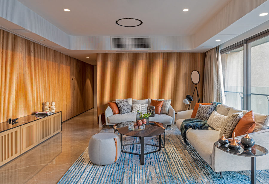 Cabin-like family room design with wooden walls, abstract-printed carpet and many colourful cushions