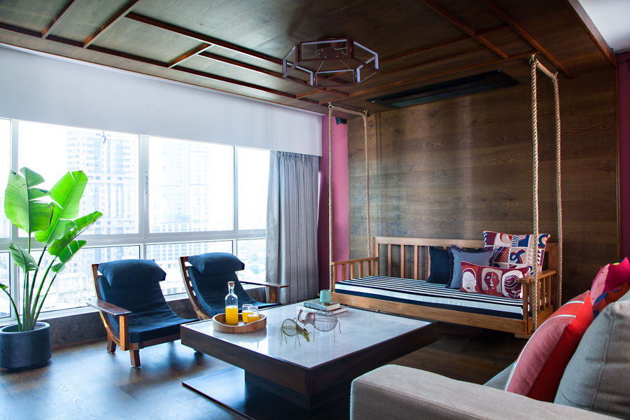 Modern family room with city view and sleek furniture, indoor swing and colourful cushions