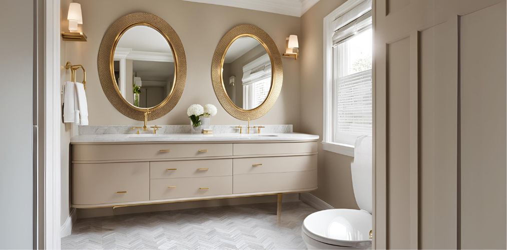 Contemporary beige bathroom design with gold-framed oval mirror - Beautiful Homes